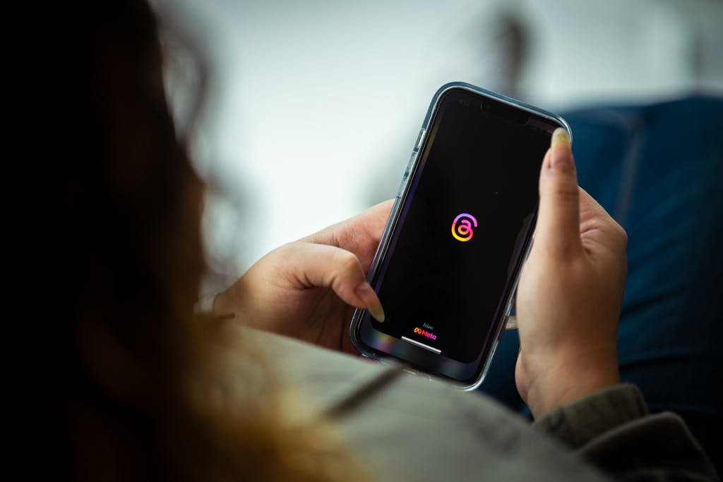 Close-up of a person holding a smartphone with a social media app open